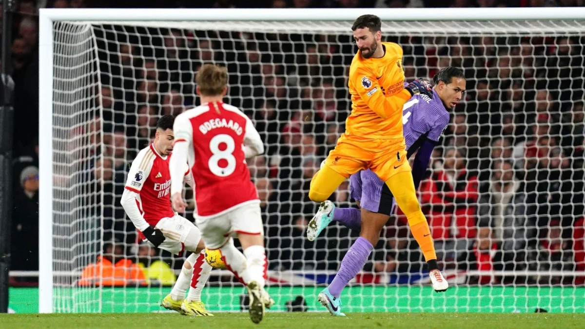 Arsenal's Gabriel Martinelli (left) scores their side's second goal of the game after Liverpool goalkeeper Alisson Becker and Virgil van Dijk (right) fails to clear the ball during the Premie