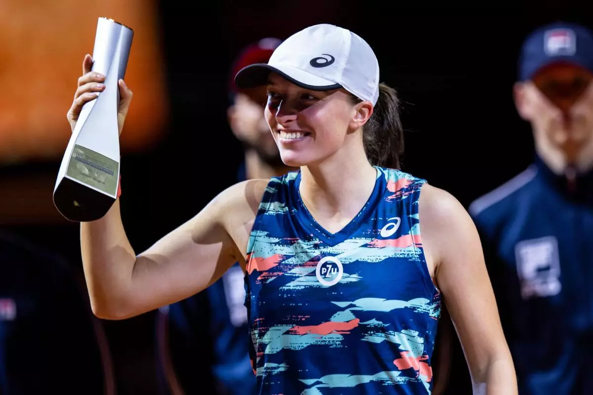 Iga Swiatek from Poland cheers with the trophy at the award ceremony.