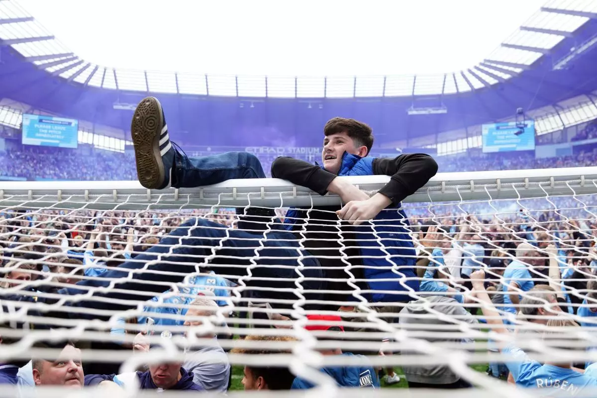 Manchester City fans invade the pitch after their side won the Premier League