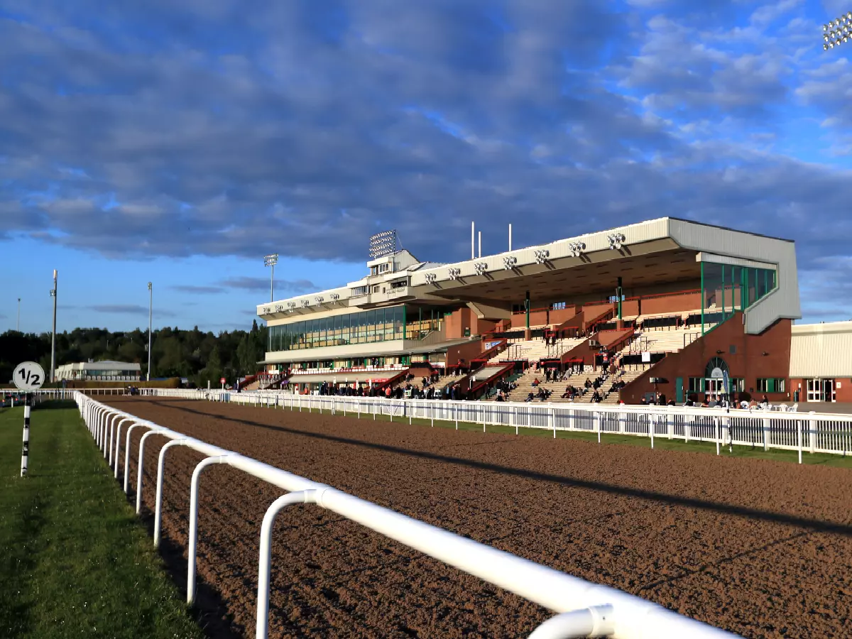 Fresh ground with a view of a grandstand at Dunstall Park, Wolverhampton Racecourse, Wolverhampton, May 2021