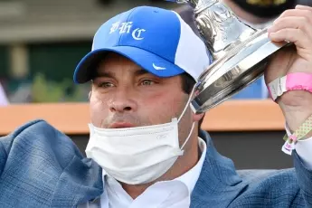 Horse Trainer Brad Cox hoists the trophy after winning the Kentucky Oaks at Churchill Downs. Credit Jamie Rhodes - USA Today Sports/ SIPA USA