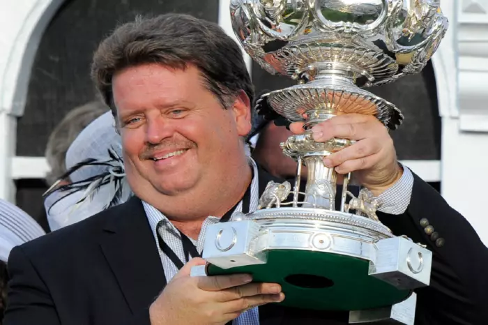 Trainer Dale Romans lifts the Woodlawn Vase after winning the 136th Preakness Stakes at Pimlico Race Course in Baltimore, Maryland