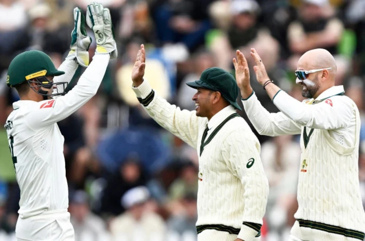 Australian wicketkeeper Alex Carey, left, celebrates with teammates Usman Khawaja and bowler Nathan Lyon, right, following the dismissal of New Zealand's Kane Willliamson on day three of the