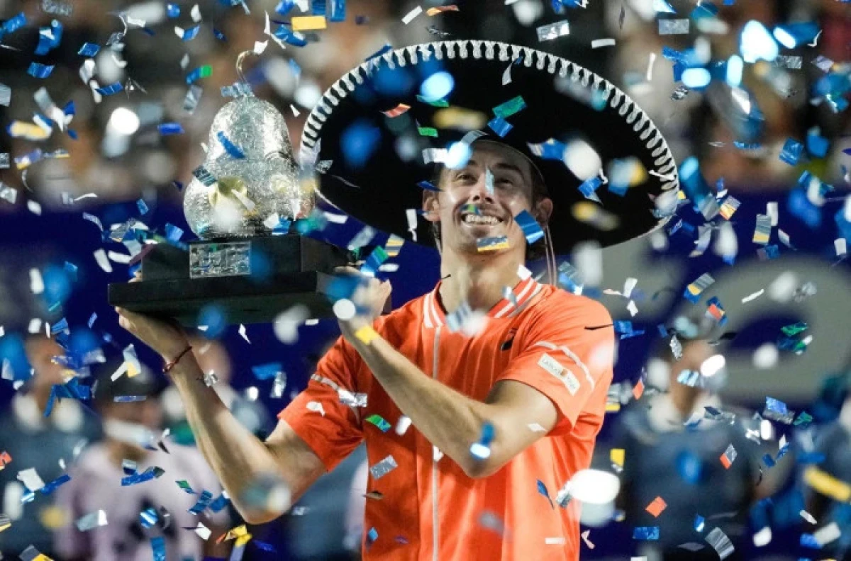Alex de Minaur of Australia holds up his trophy after beating Casper Ruud of Norway during the final match of the Mexican Open tennis tournament in Acapulco
