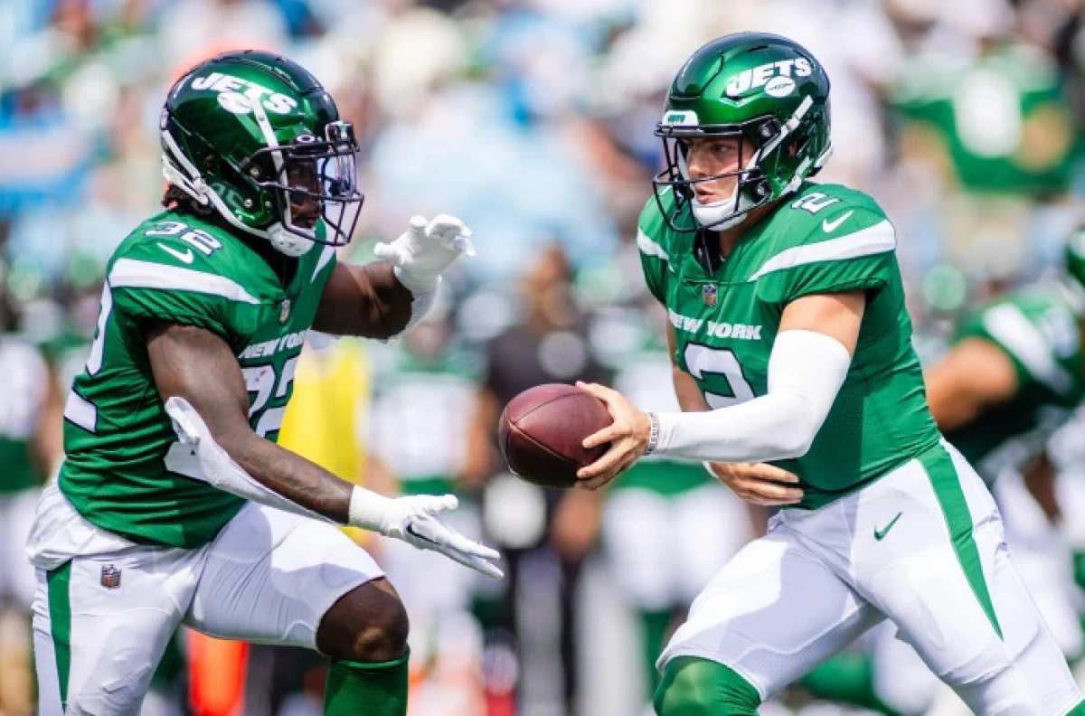 New York Jets quarterback Zach Wilson (2) hands off to running back Michael Carter - Aug 2023