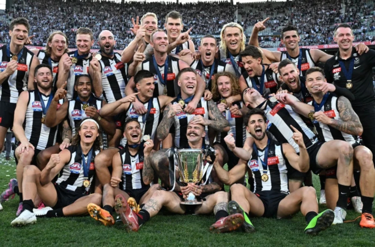 Magpies players celebrate with the AFL Premiers Cup