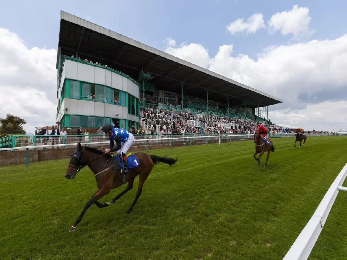 A general view of horses passing the grandstand at Brighton Racecourse, Brighton.