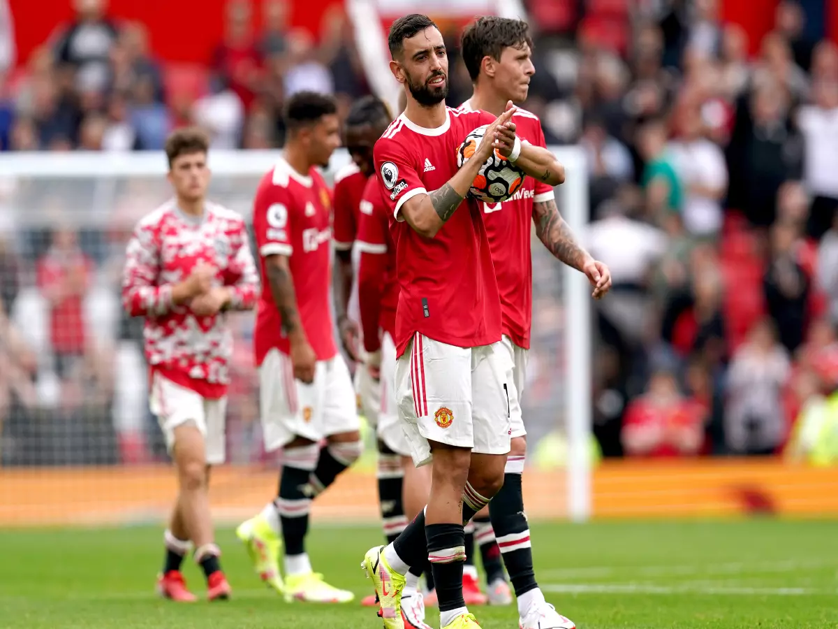 Manchester United's Bruno Fernandes holds the match ball as he applauds the fans at the end of the Premier League match at Old Trafford