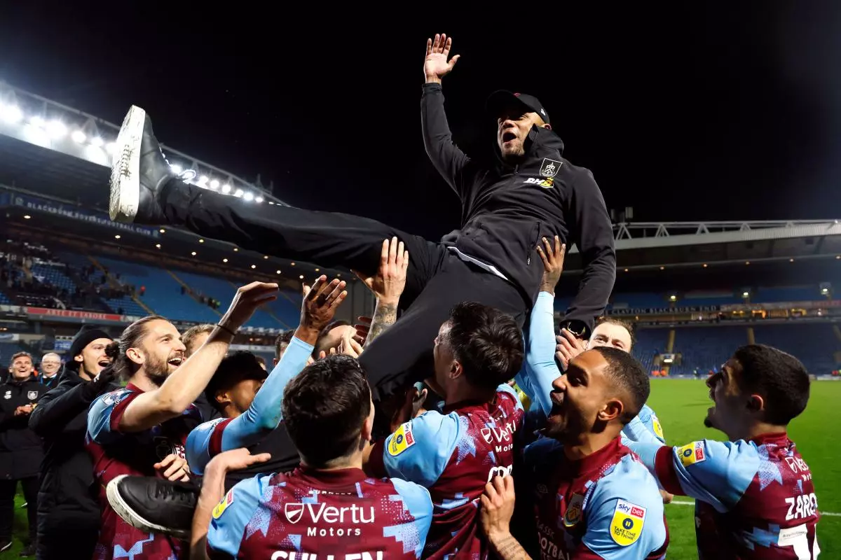 Burnley players lift manager Vincent Kompany after winning the Championship - April 2023