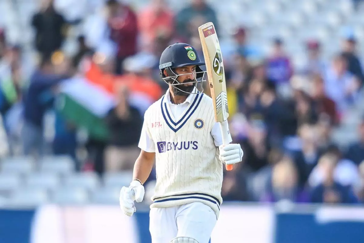 Cheteshwar Pujara of India celebrates a half century
