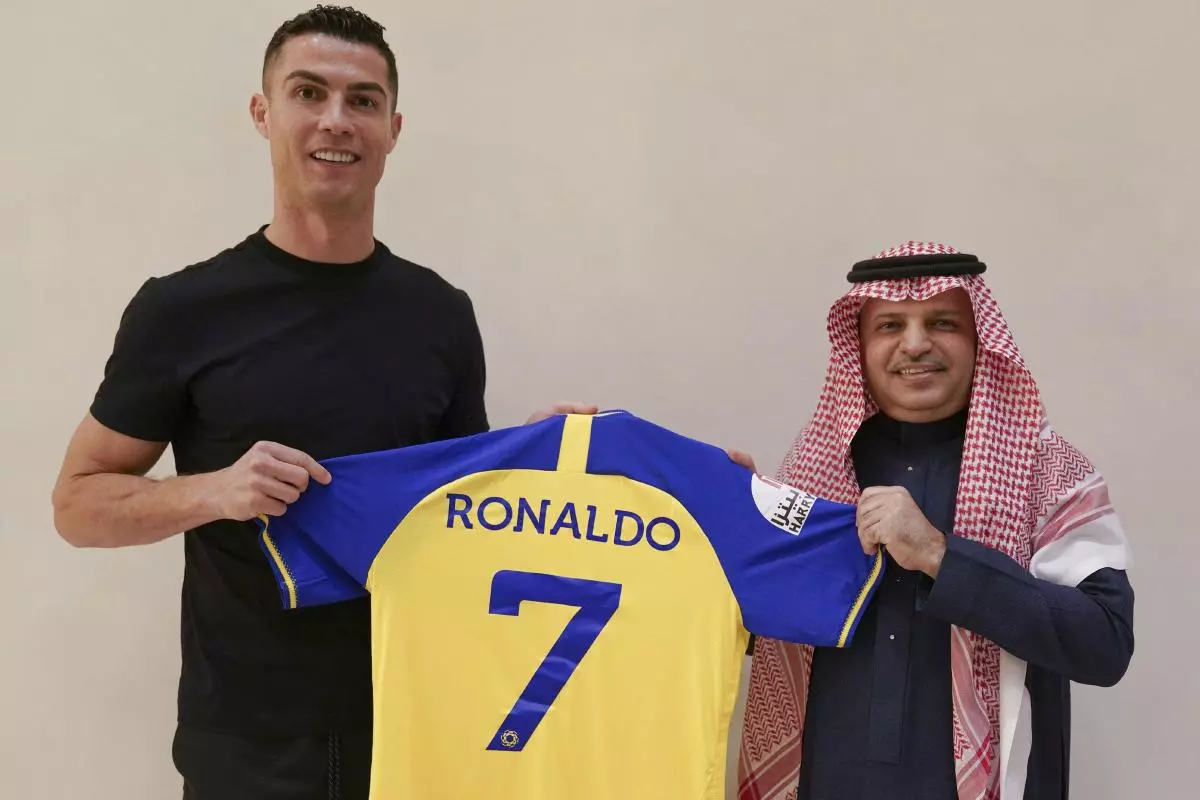 Cristiano Ronaldo holds a team jersey of Saudi Arabian club Al Nassr