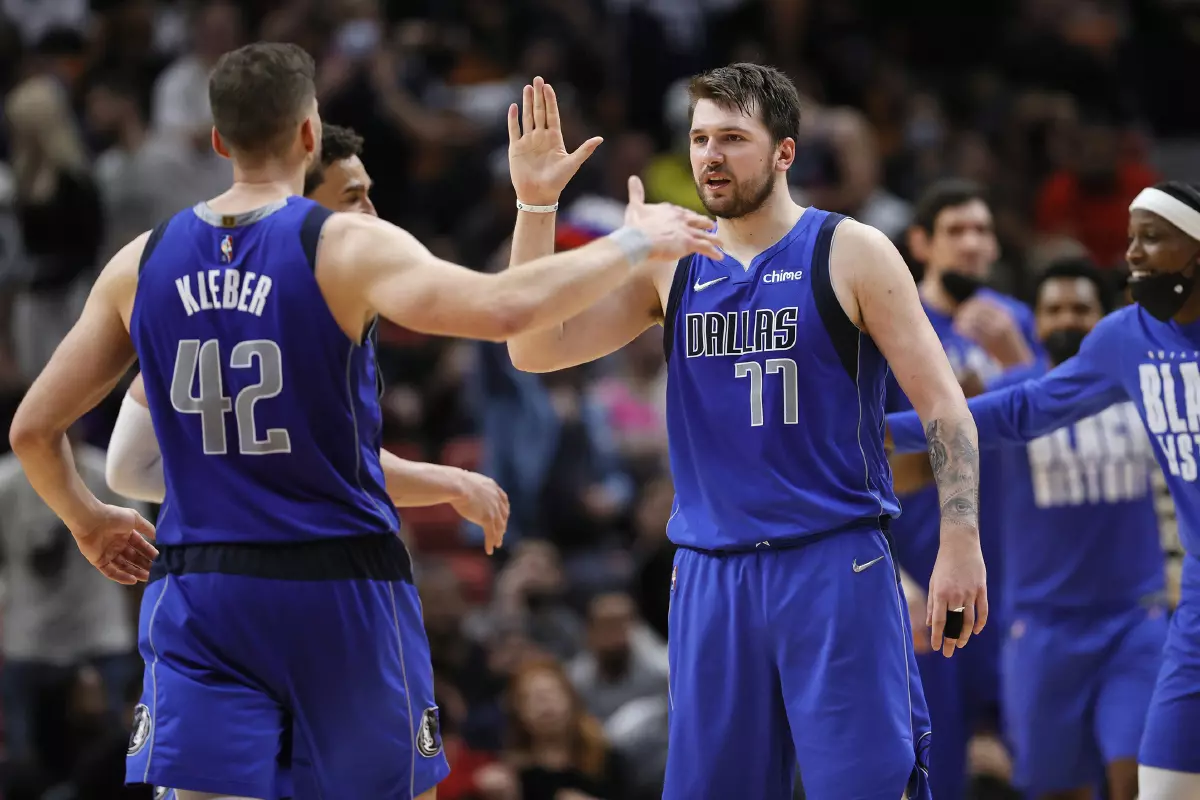 The Dallas Mavericks' Maxi Kleber (42) is congratulated by teammate Luka Doncic (77)