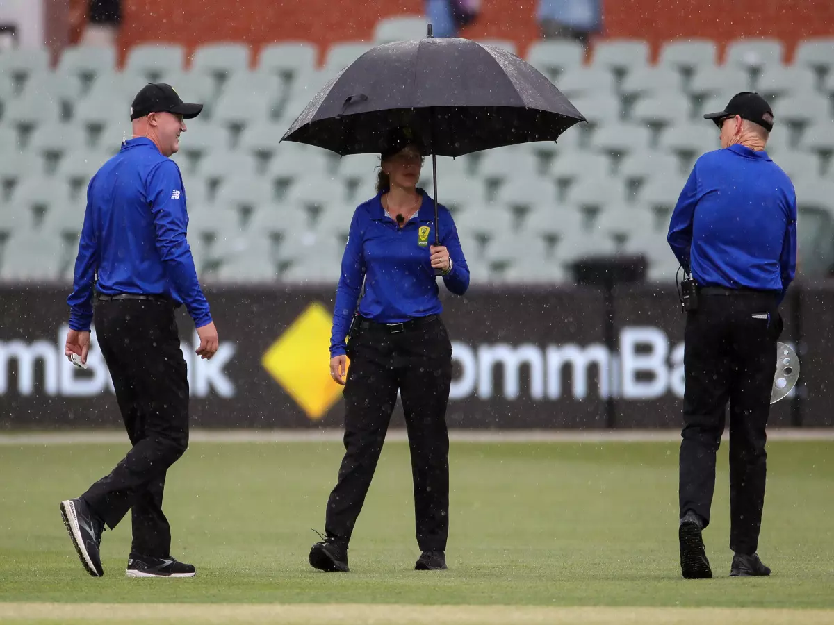 The umpires leave the field as the rain comes down and play is interrupted during the second T20