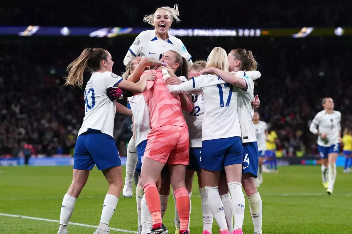 England's Chloe Kelly celebrates scoring the winning penalty of the shoot-out with team-mates following the Women's Finalissima at Wembley Stadium - April 2023