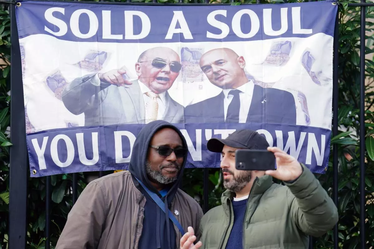 Fans take a selfie in front of a fan demonstration against Tottenham's ownership - April 2023