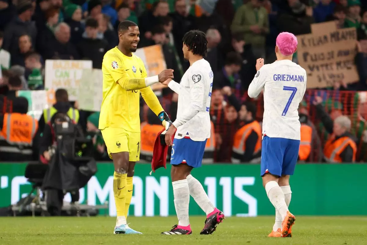 France goalkeeper Mike Maignan celebrates the victory with Jules Kounde, Antoine Griezmann of France - March 2023