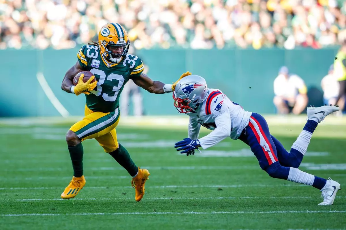 Green Bay Packers running back Aaron Jones stiff arms New England Patriots defensive back Jack Jones