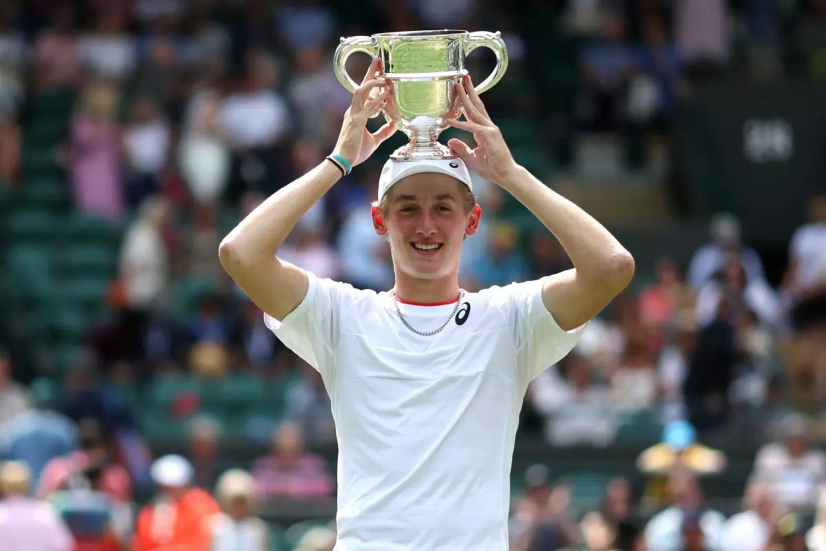 Henry Searle celebrates with the trophy after victory against Yaroslav after the Boys' Singles Final