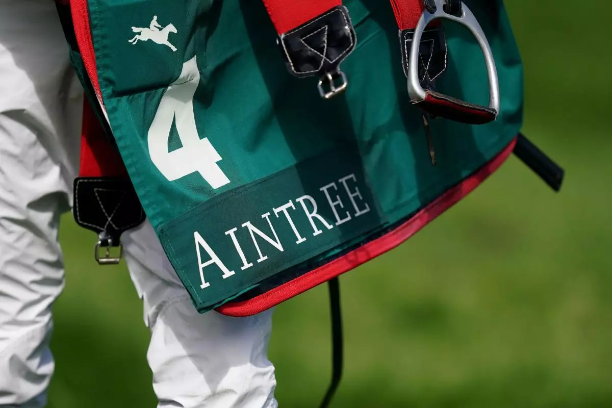 A jockey carries a saddle pad on day one of the Randox Grand National Festival at Aintree
