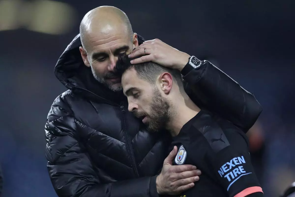 Manchester City manager Pep Guardiola celebrates after the match with Bernardo Silva