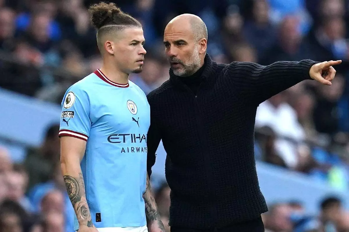 Manchester City manager Pep Guardiola speaks to Kalvin Phillips