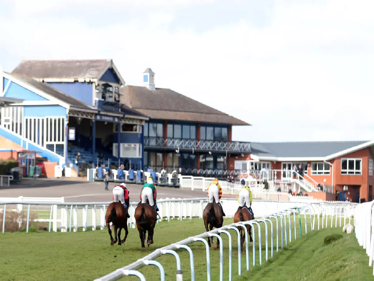 Runner and riders head towards the empty grandstand during the Racing TV Profits Returned To Racing Handicap Chase at Leicester Racecourse.