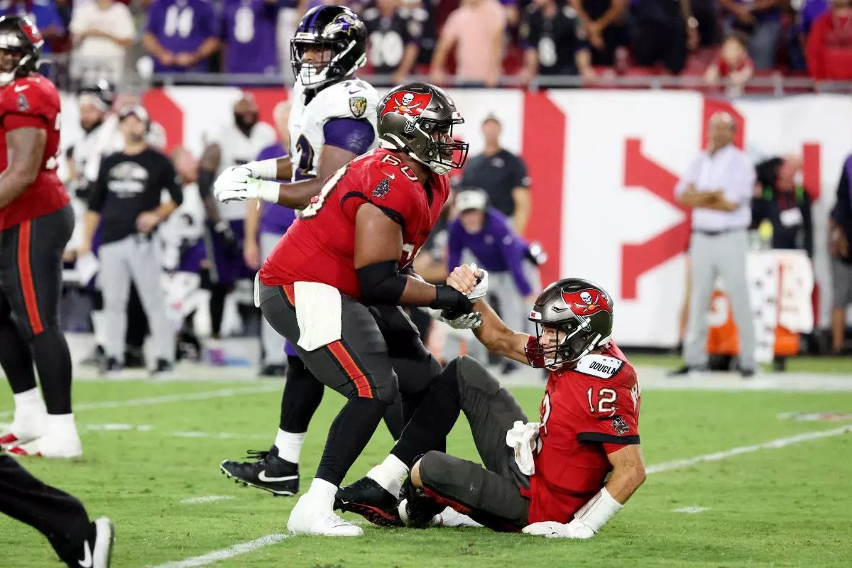 Tampa Bay Buccaneers guard Nick Leverett helps Tampa Bay Buccaneers quarterback Tom Brady off the field - October 2022