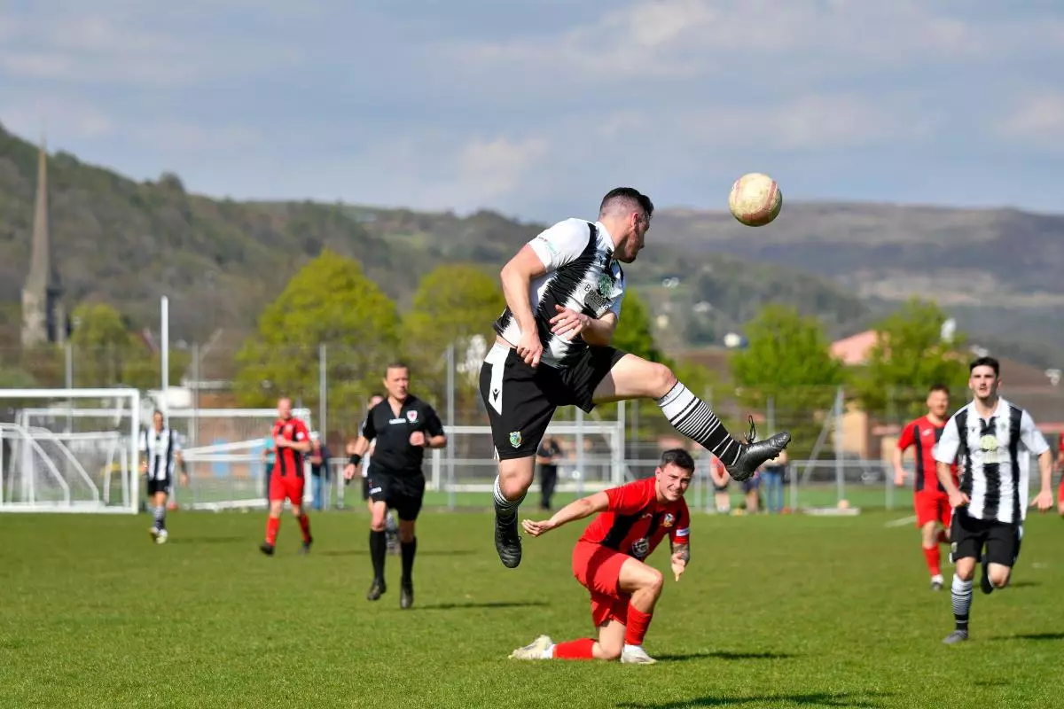 Tom Grey of Pontardawe Town heads the ball away during the Ardal South West League game - April 2022