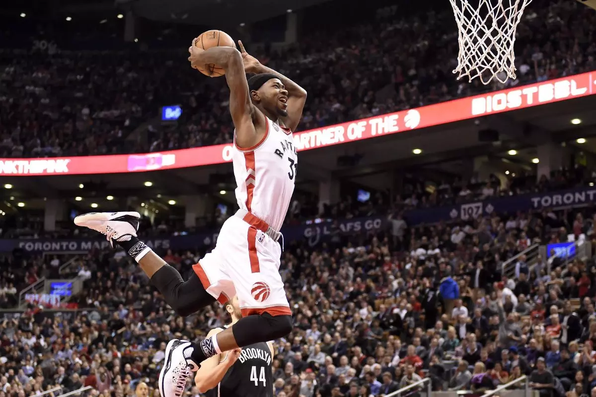 Toronto Raptors' Terrence Ross soars with the ball for a dunk through the Brooklyn Nets' net during second half NBA basketball action
