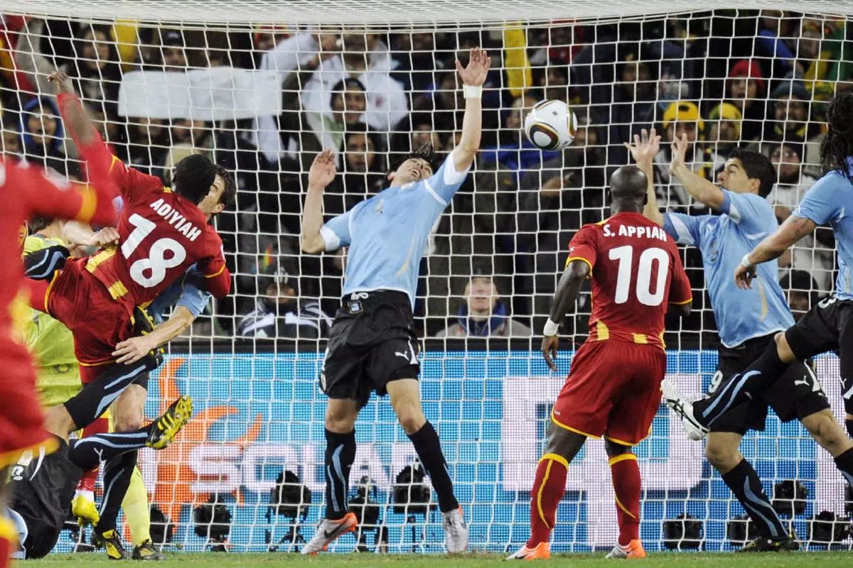 Uruguay's Luis Suarez (2nd from R) stretches his arms to block a shot by Ghana