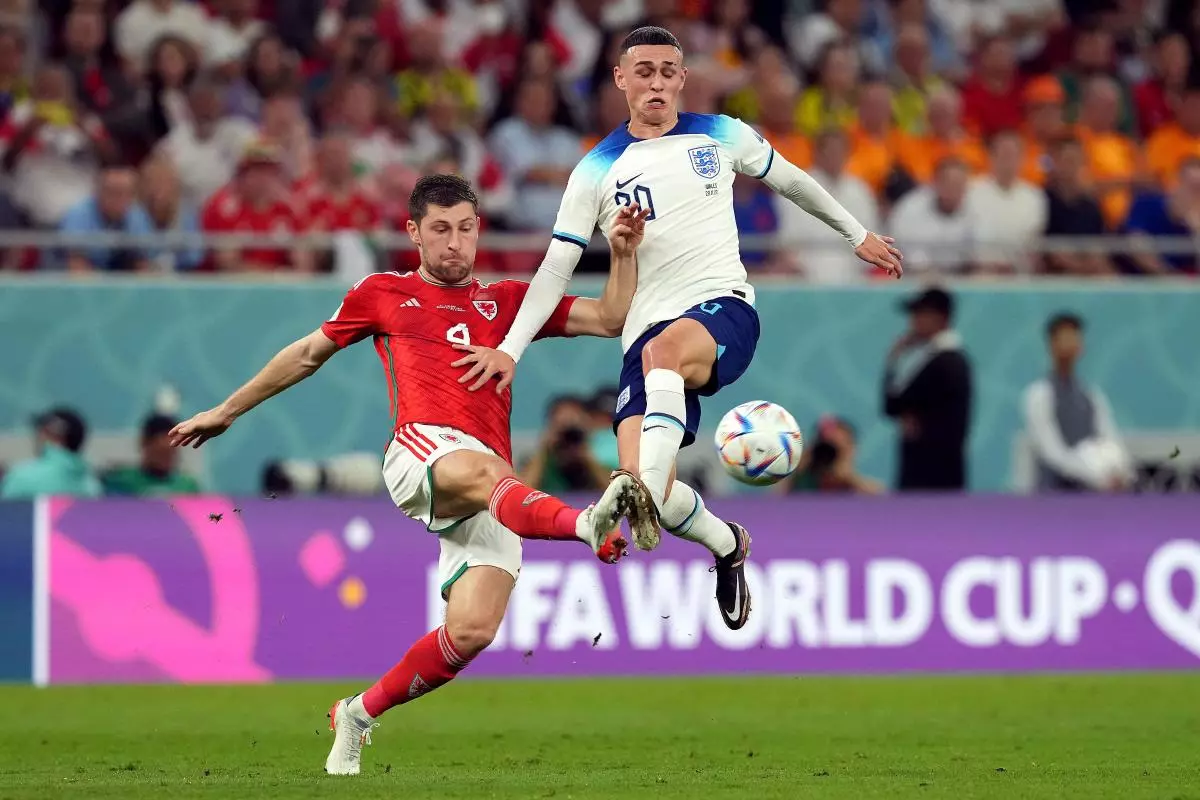 Wales’ Ben Davies and England’s Phil Foden (right) battle for the ball during the FIFA World Cup