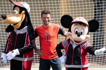 Thomas Müller stands together with Goofy and Mickey Mouse as Bayern Munich train for the Club World Cup