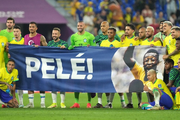 Brazil players with Pele banner