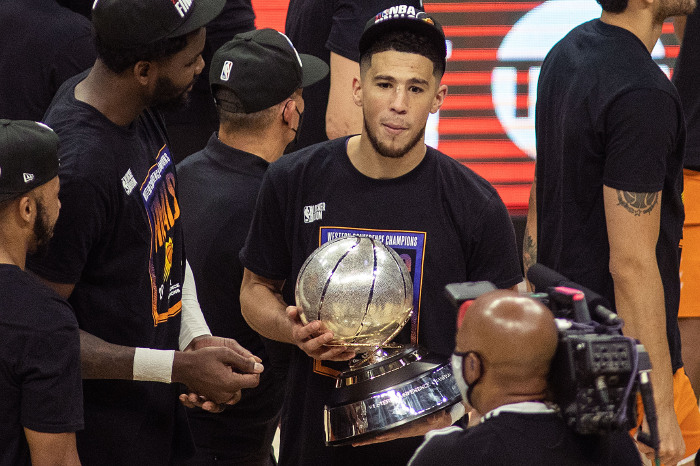 Phoenix Suns' Devin Booker holds the Western Conference Finals Trophy
