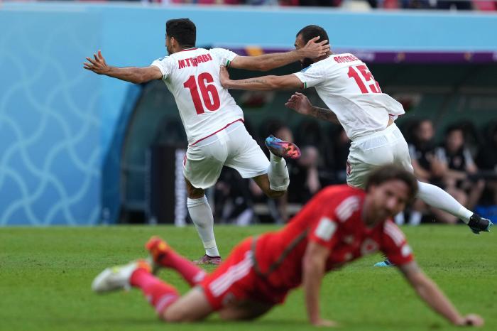 Iran's Roozbeh Cheshmi (right) celebrates scoring their side's first goal against Wales