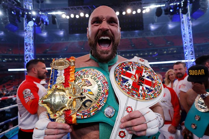 Tyson Fury with his heavyweight titles